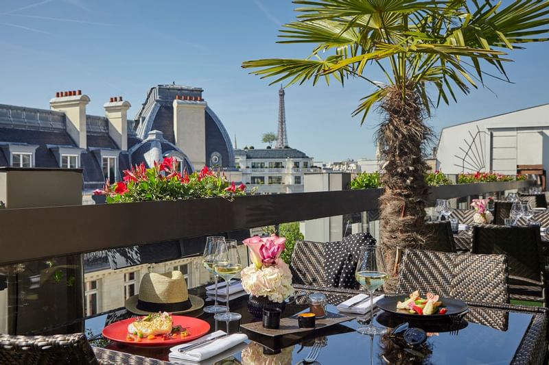 Terrace dining area with meals on the table at Warwick Paris with a scenic view