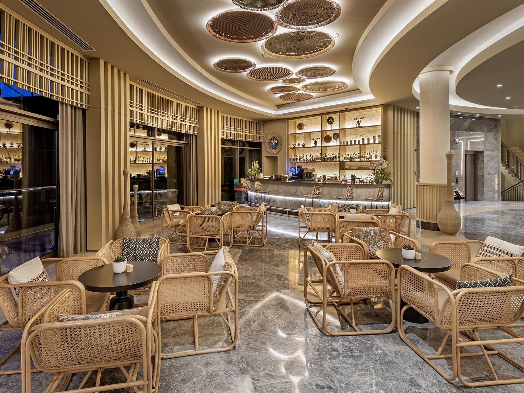 At Titanic Luxury Collection Bodrum, the luxurious lobby bar stands out with rattan furniture and elegant interior design.
