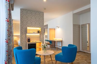 Living area with coffee station, couch, comfy chairs, coffee table in Junior Suite at Metropol Hotel