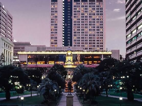 A large hotel of Sofitel Brisbane Central stands prominently with a clock tower rising in the background