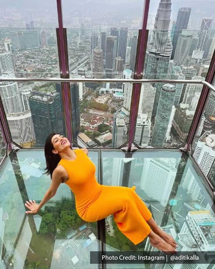 Woman posing on the Sky Deck of Menara Kuala Lumpur Tower with an aerial view of the city near Imperial Lexis KL