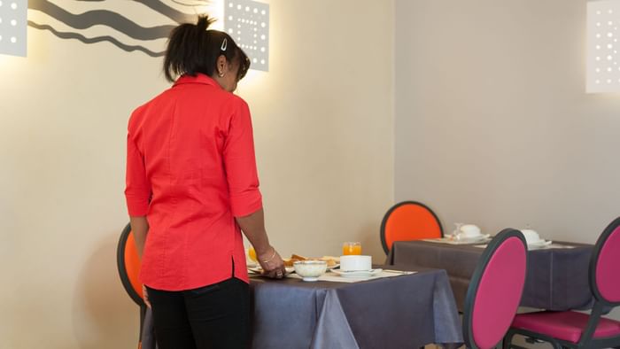 A waitress arranging a table at Hotel Le Pariou