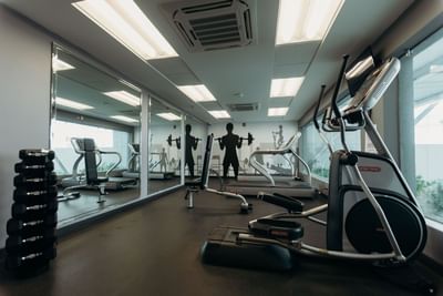 Gym equipment by a mirror wall at Hotel Mirra, ideal for guests searching where to stay in San Luis Rio Colorado near Garita