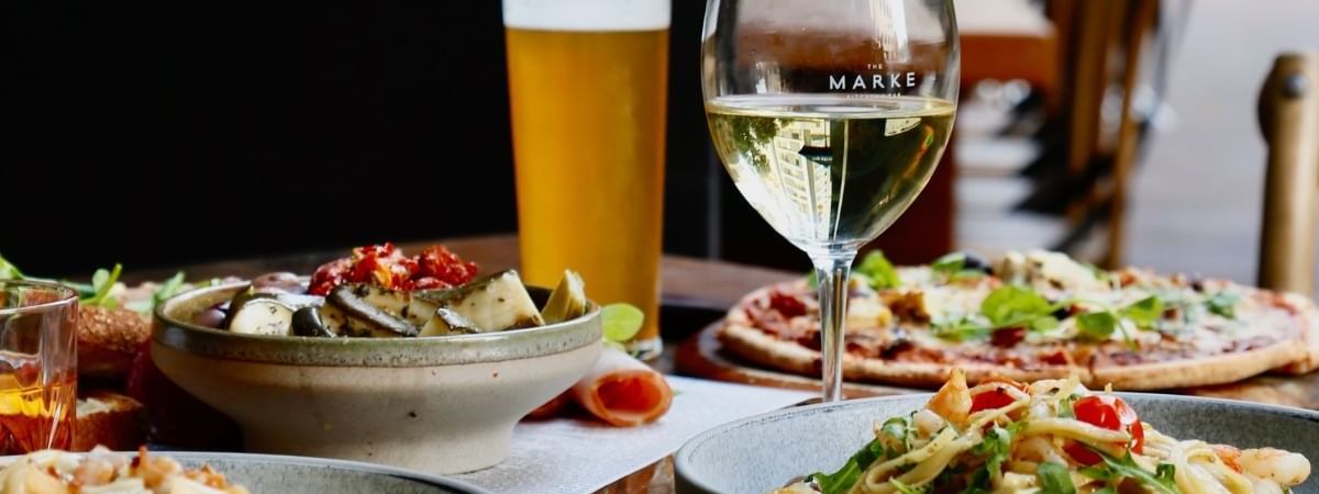 White wine, beer, pizza, and pasta served together in The Marke Kitchen at Novotel Sydney International Airport