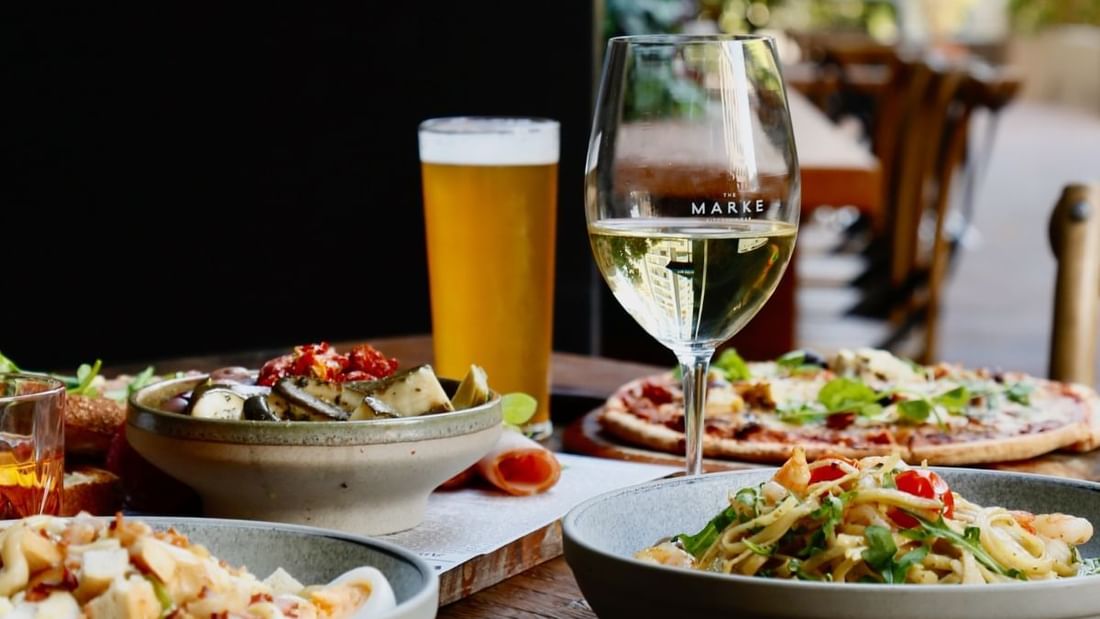 White wine, beer, pizza, and pasta served together in The Marke Kitchen at Novotel Sydney International Airport
