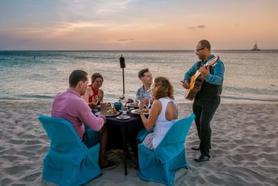 People dining at a beachside table in Passions on the Beach Restaurant near Amsterdam Manor Beach Resort