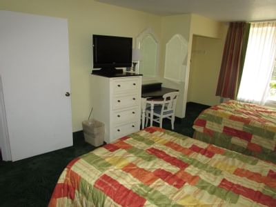 Hotel room with two beds, desk and TV