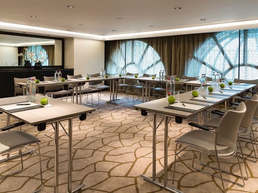 U-shape Barsey II meeting setup with green apples and bottled water on the table at Hotel Barsey by Warwick