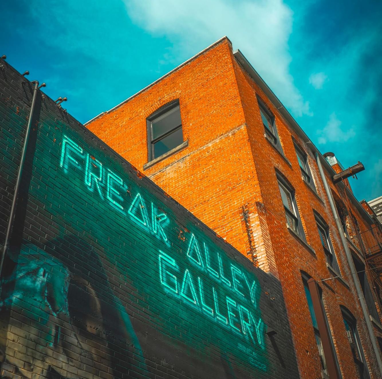 Freak Alley Gallery with a bright turquoise neon sign near Hotel 43 Boise