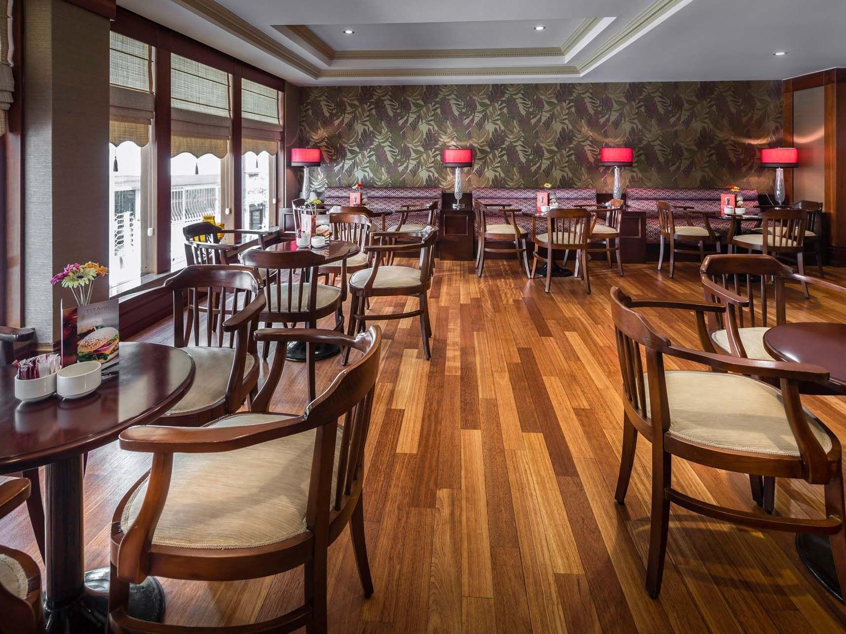 The dining area with wooden banquets in Lobby Cafe & Bar at Titanic Comfort Sisli