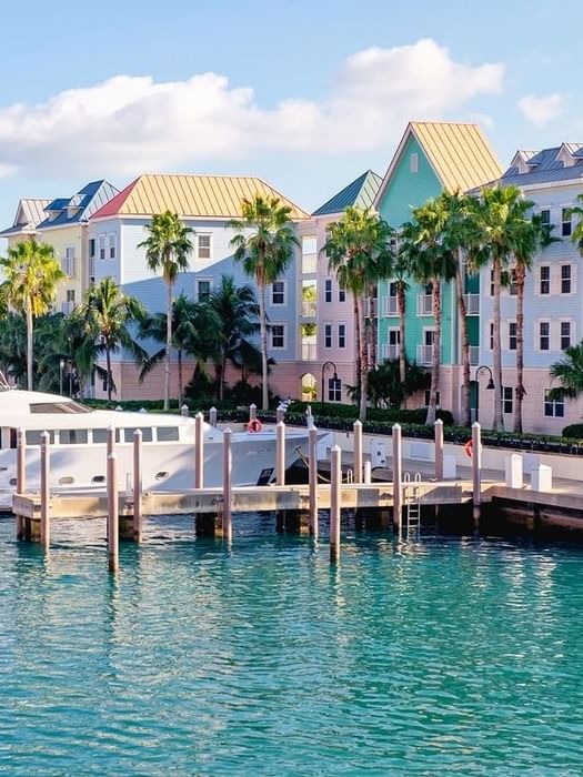 Yacht by a wooden pier under colorful buildings in Downtown Nassau near Warwick Paradise Island Bahamas