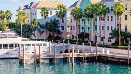 Yacht by a wooden pier under colorful buildings in Downtown Nassau near Warwick Paradise Island Bahamas