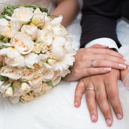 Close-up of Bride's hand on groom's next to bridal bouquet at One World Hotel in Petaling Jaya