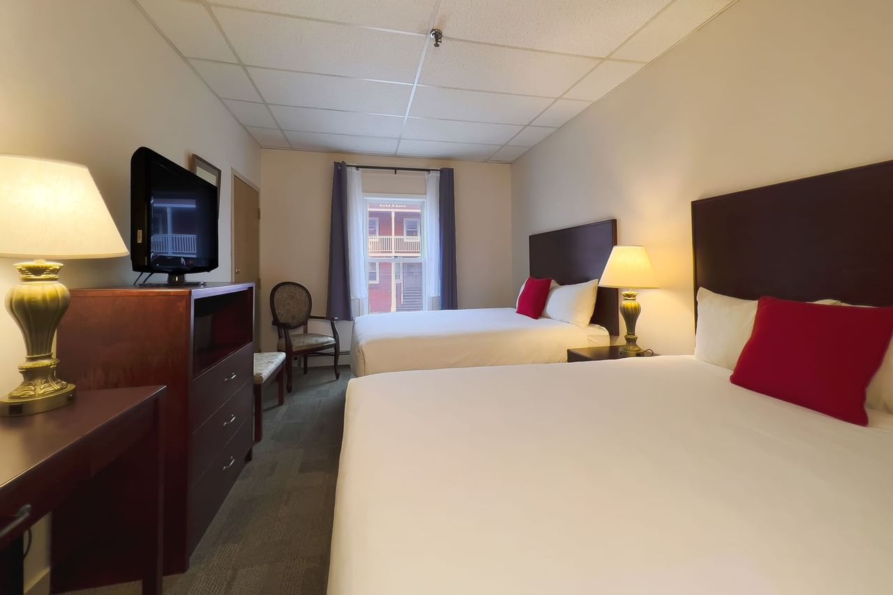 Guest room with two beds, tv, window, mirror, chair