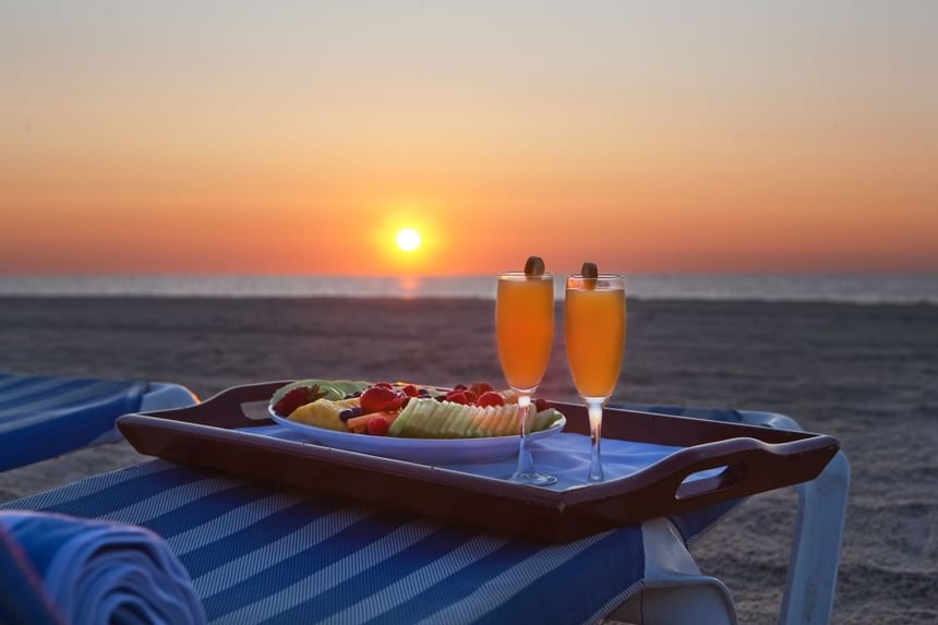 Cocktails & fruits served on a beach at Ocean Place at sunset