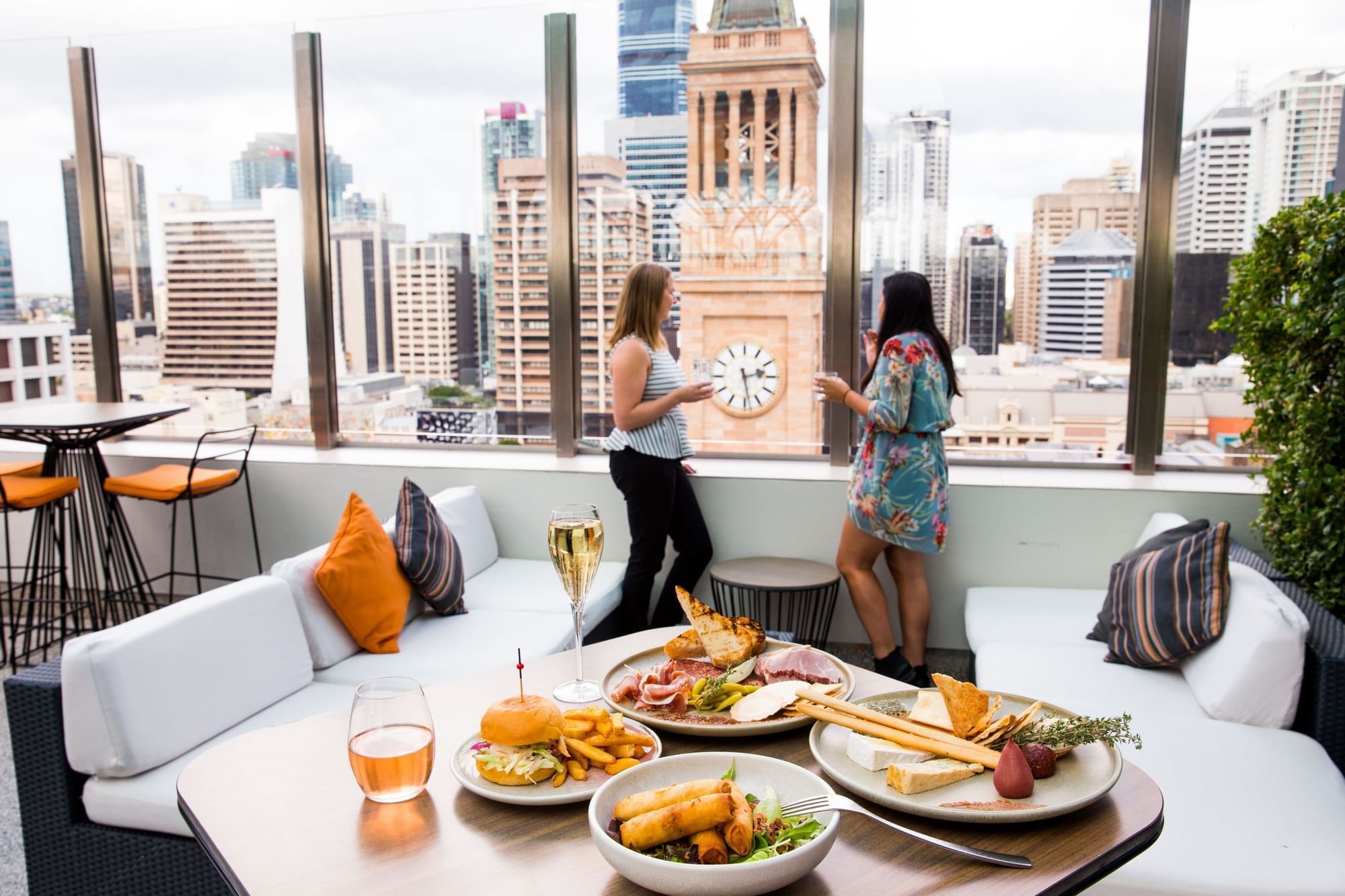 Two ladies standing next to a table with food and drinks at Pullman King George Square