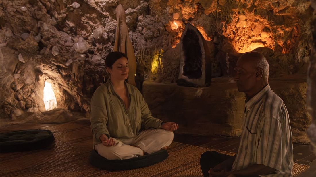 Man and a woman meditating in group wellness classes held at The Banjaran Hotsprings Retreat