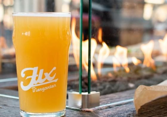 A beer glass on a table with a fire pit in the background at Catalina Island Company