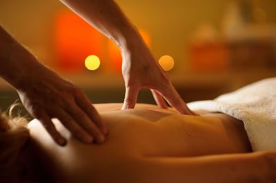 Manos de terapeuta dando masaje de espalda a un huésped en Noi Spa, spa en Santiago de Chile, en NOI Vitacura