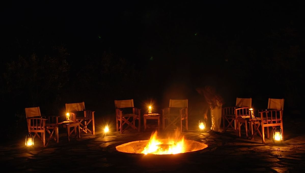 Chairs around the firepit at night at Mbuzi Mawe Serena Camp