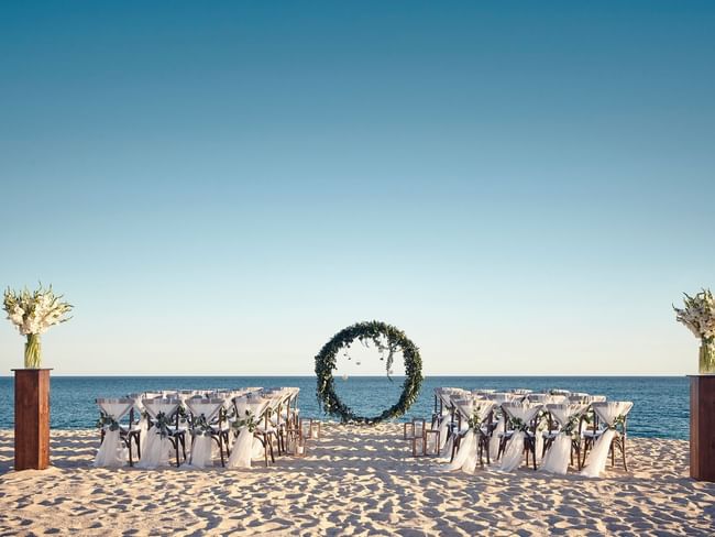 Impresionante ceremonia en la playa con un arco floral circular y vista al mar en Hacienda del Mar Los Cabos