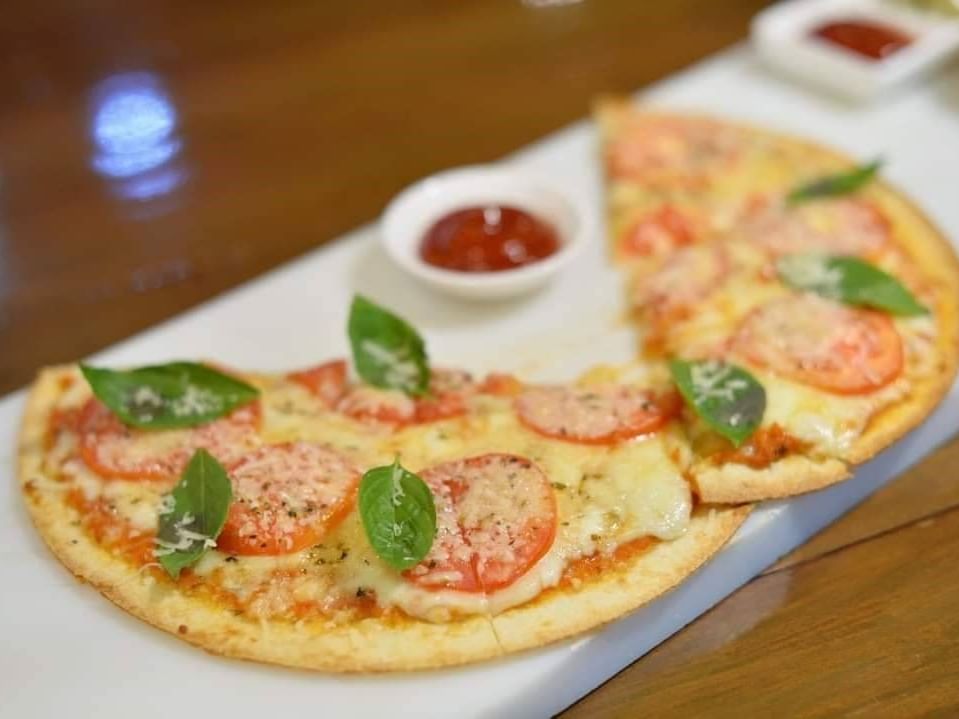 Two pizza slices served with sauce at Maitria Mode Sukhumvit 15