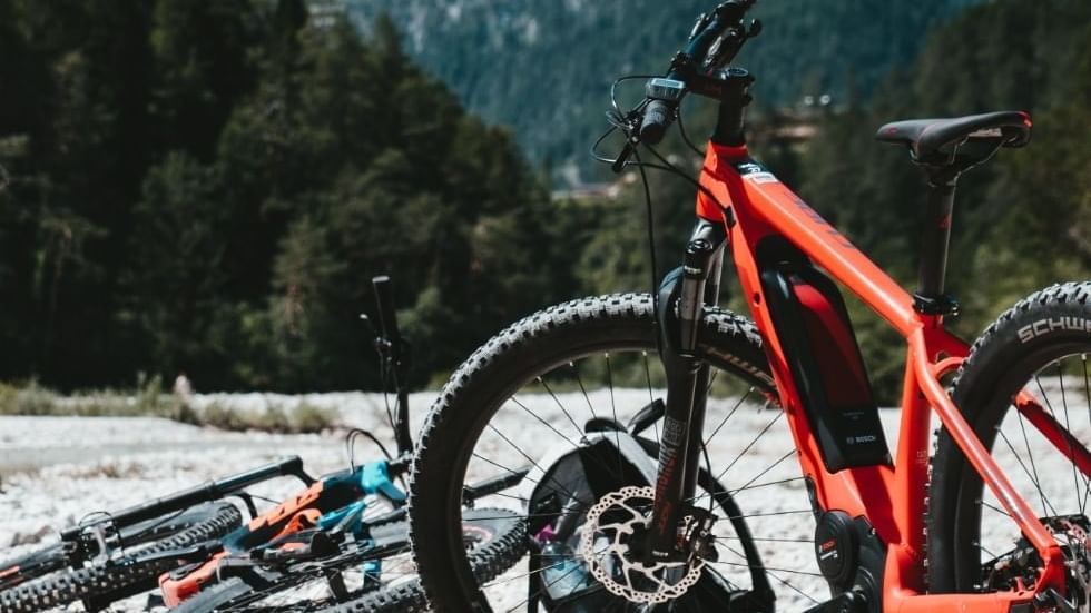 Mountain bikes on rocky ground with forested mountains in the background near Falkensteiner Hotel Cristallo