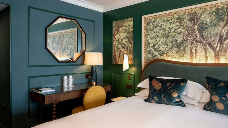 Executive King Room with a forest-themed wall mural at Warwick Hotels and Resorts, showcasing the desk and mirror