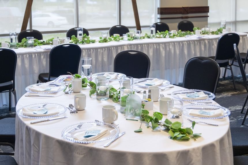 Table setup with greenery vines by black chairs at Rodd Brudenell River Resort, a premier wedding venue in PEI