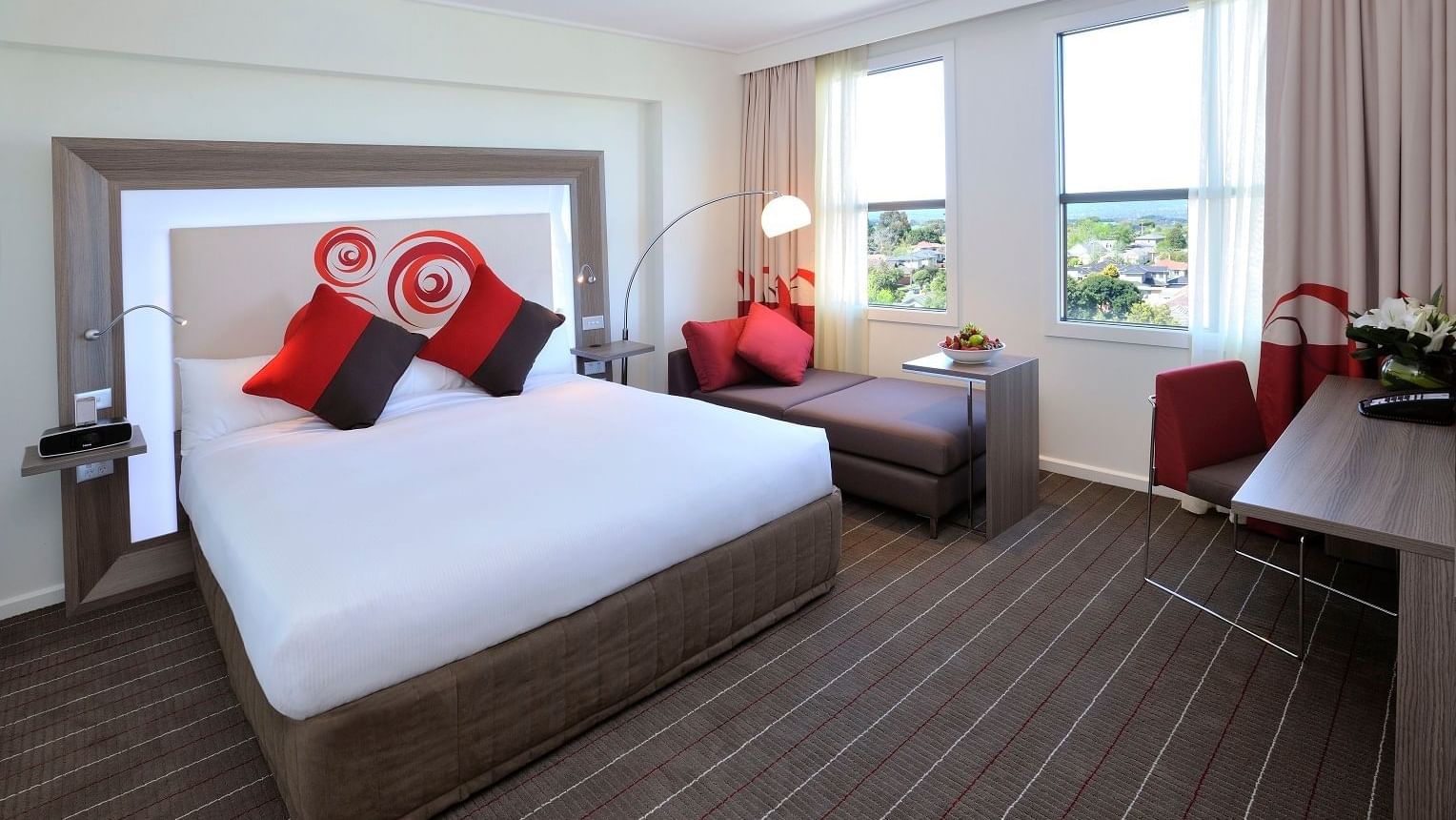 Bed & lounge in Deluxe King Hotel Room at Novotel Glen Waverley