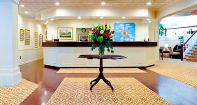 Flower arrangement on table in front of reception desk in lobby at Farmington Inn and Suites