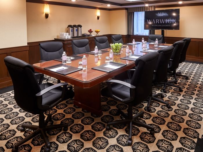 Burnham Boardroom with a large table and black chairs at Warwick Allerton Chicago