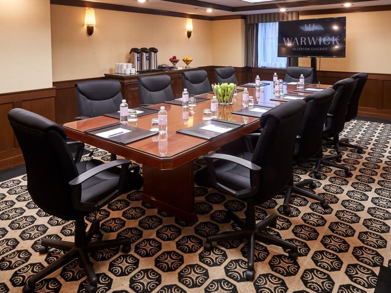 Burnham Boardroom with a large table and black chairs at Warwick Allerton Chicago
