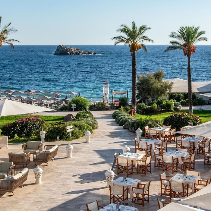 Open-air dining area with sea view in Artigiani Restaurant at Falkensteiner Resort Capo Boi