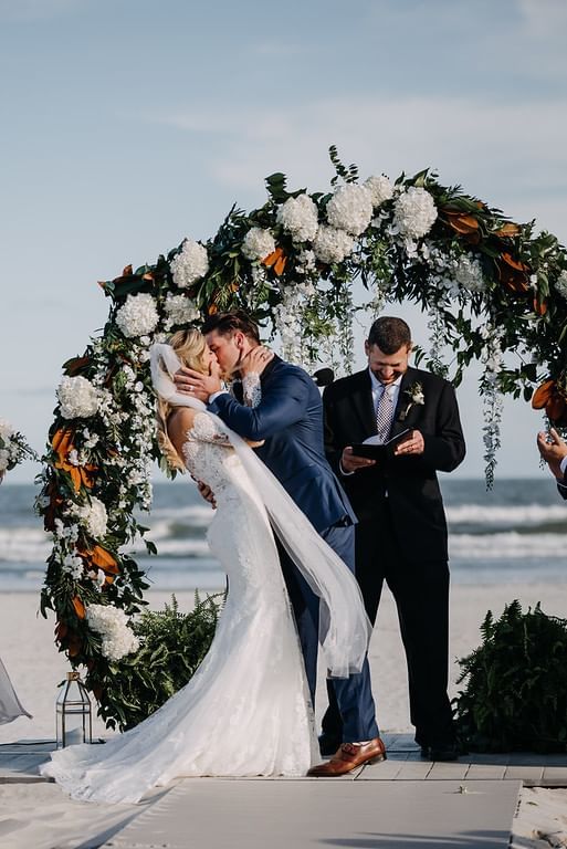 Groom kisses the bride during the ceremony at our Diamond Beach wedding venue