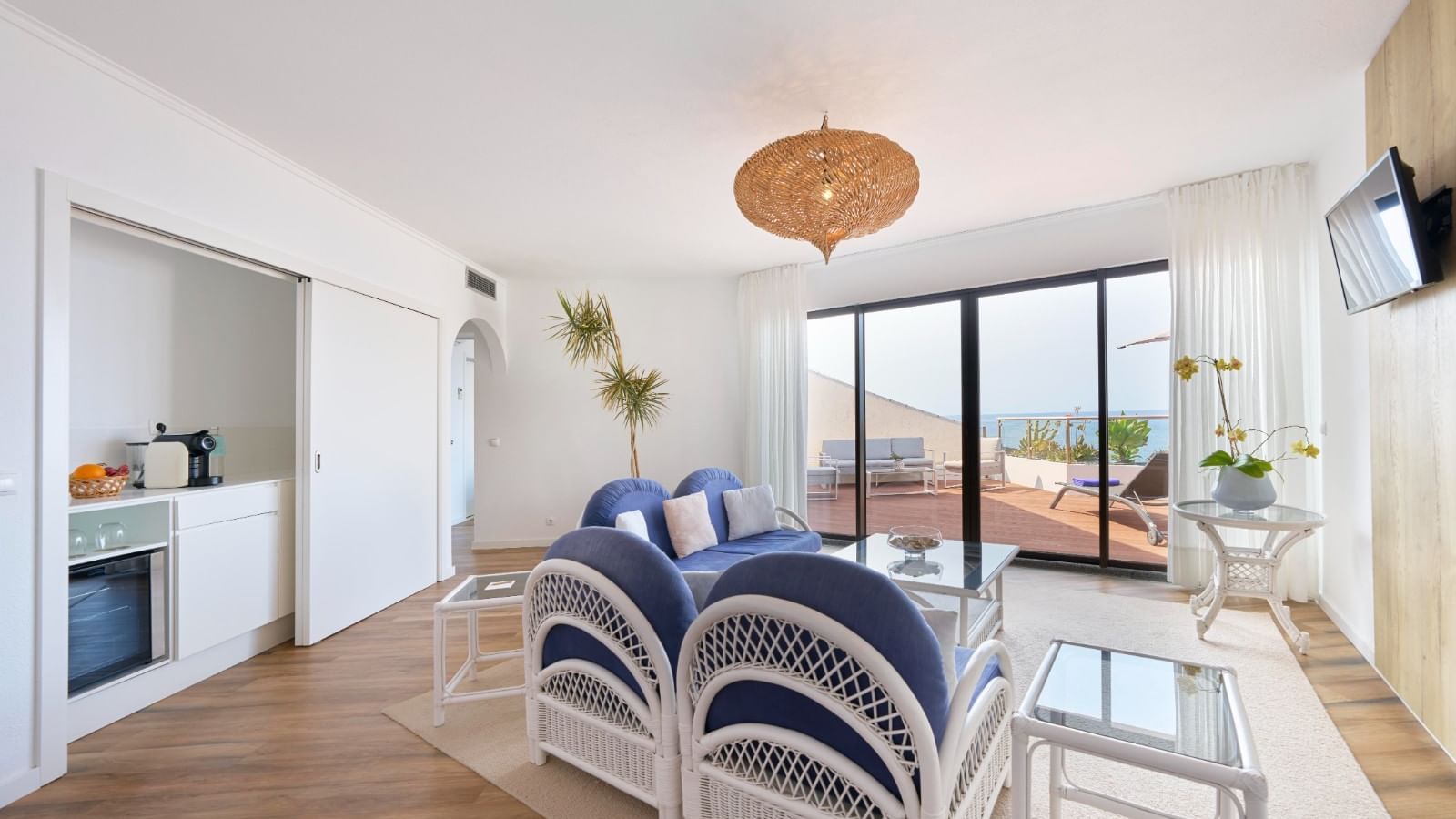 TV lounge area with cozy seating and wooden flooring in the Suite at Bensaude Hotels