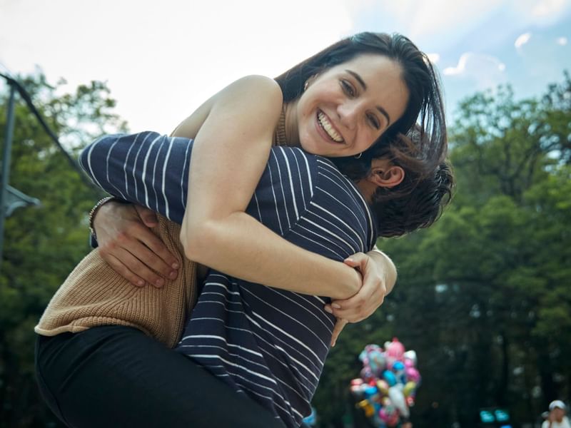 People embrace each other in a park at Fiesta Americana