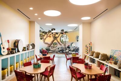 Children’s activity room with seating, musical instruments, and a stone-inspired play area at The Residences at Seafire