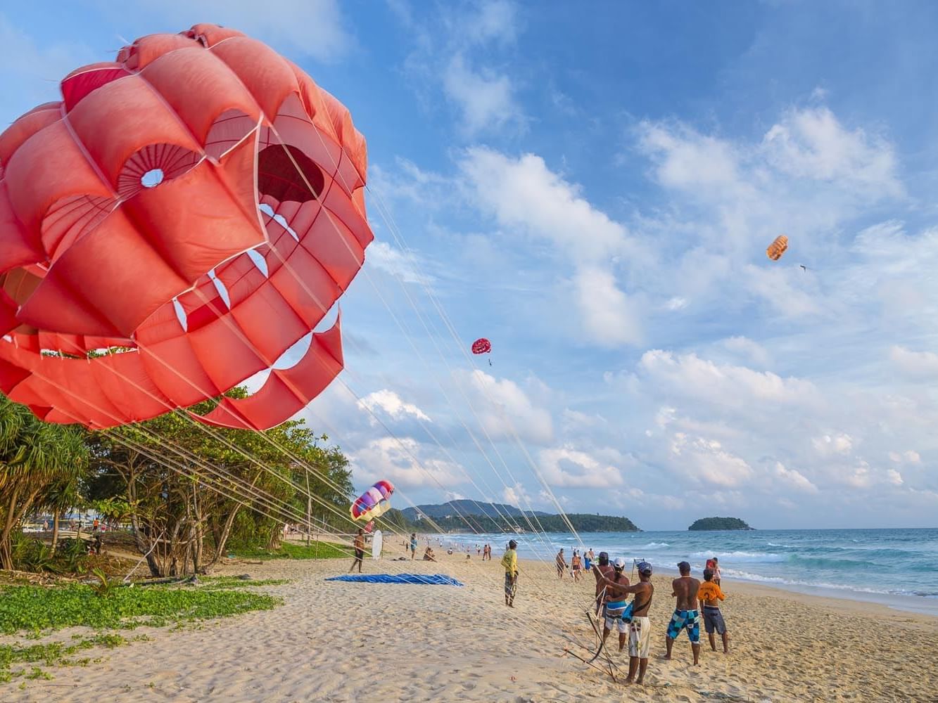 People doing beach activities near Paradox Phuket Resort