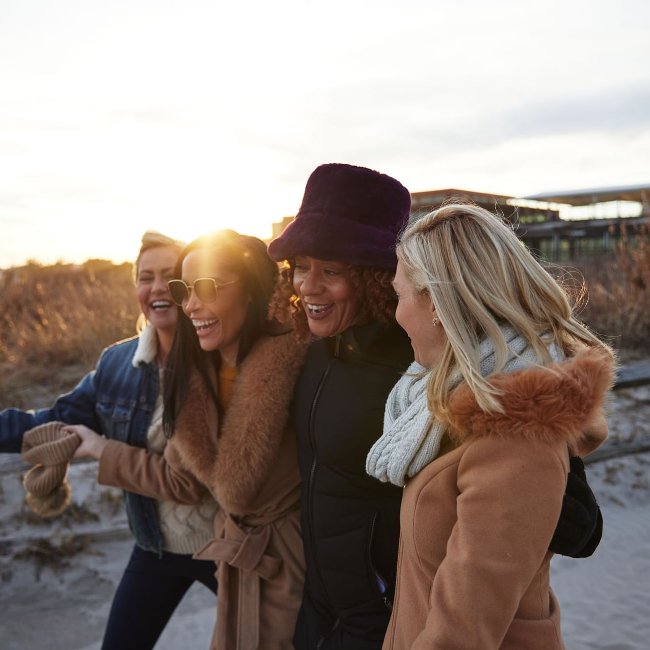 4 ladies in cozy coats walking down the path at ICONA Avalon to the beach - Girls Getaway Package to the Beach