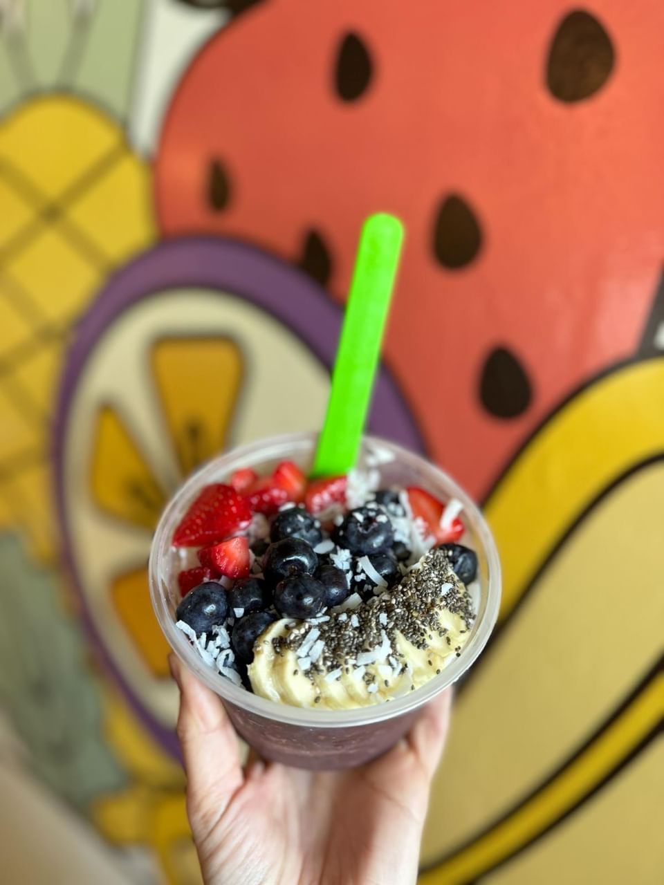 A colorful acai bowl with a green spoon in OATS Juice bar at El Conquistador Resort
