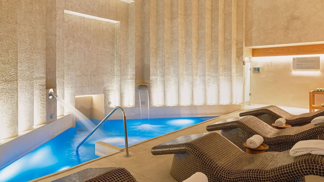Indoor pool area with lounge chairs in the Spa Room at Grand Fiesta Americana