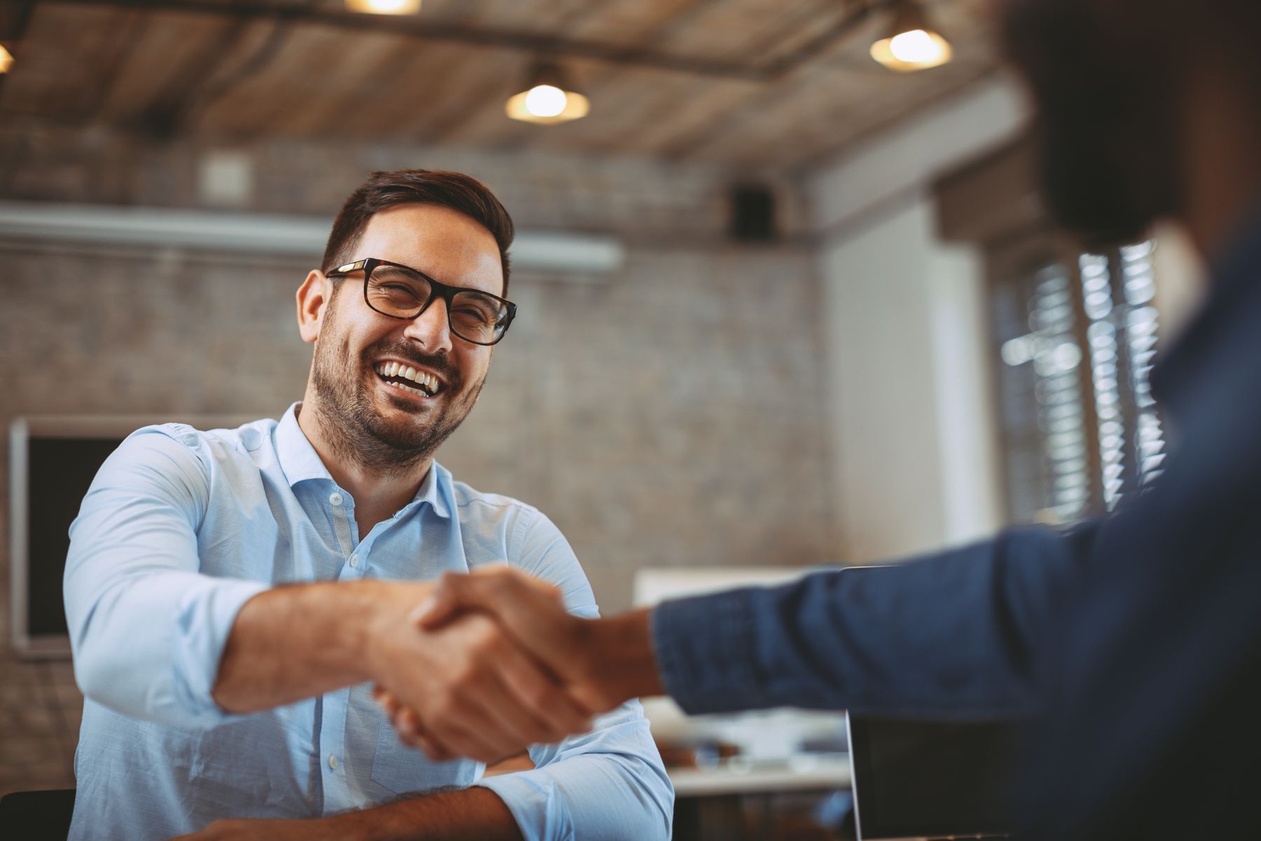 Two businessmen shaking hands and smiling