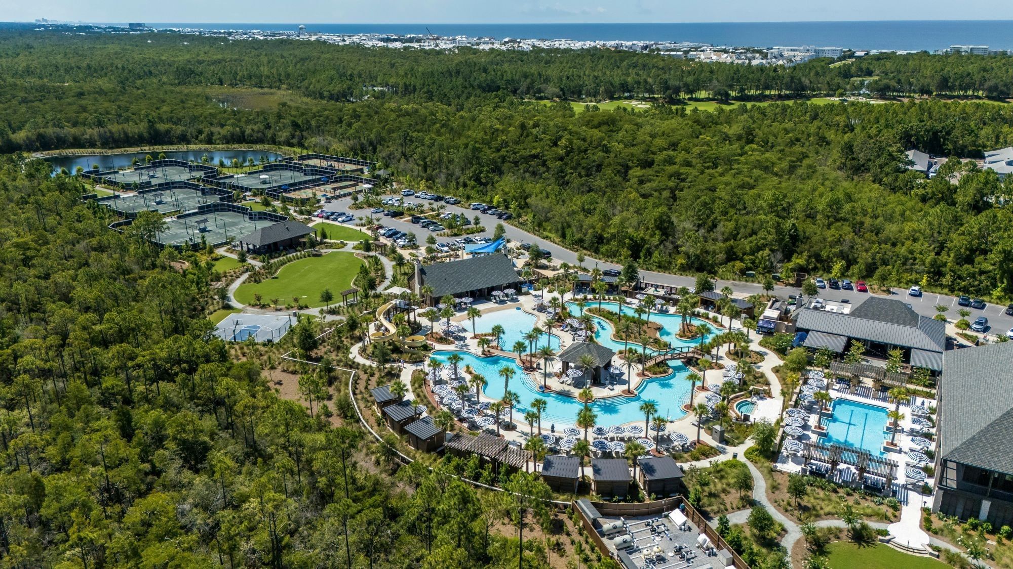 Aerial view of new Watersound Inn access to Camp Creek amenities with pools, tennis courts, and lush greenery