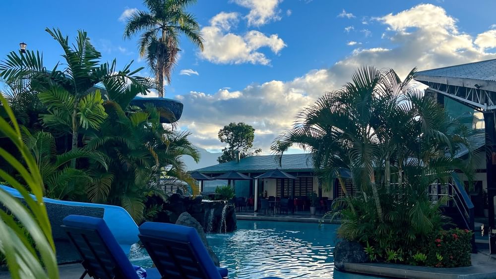 Blue loungers by a swimming pool at Tokatoka Resort in Nadi, Fiji.