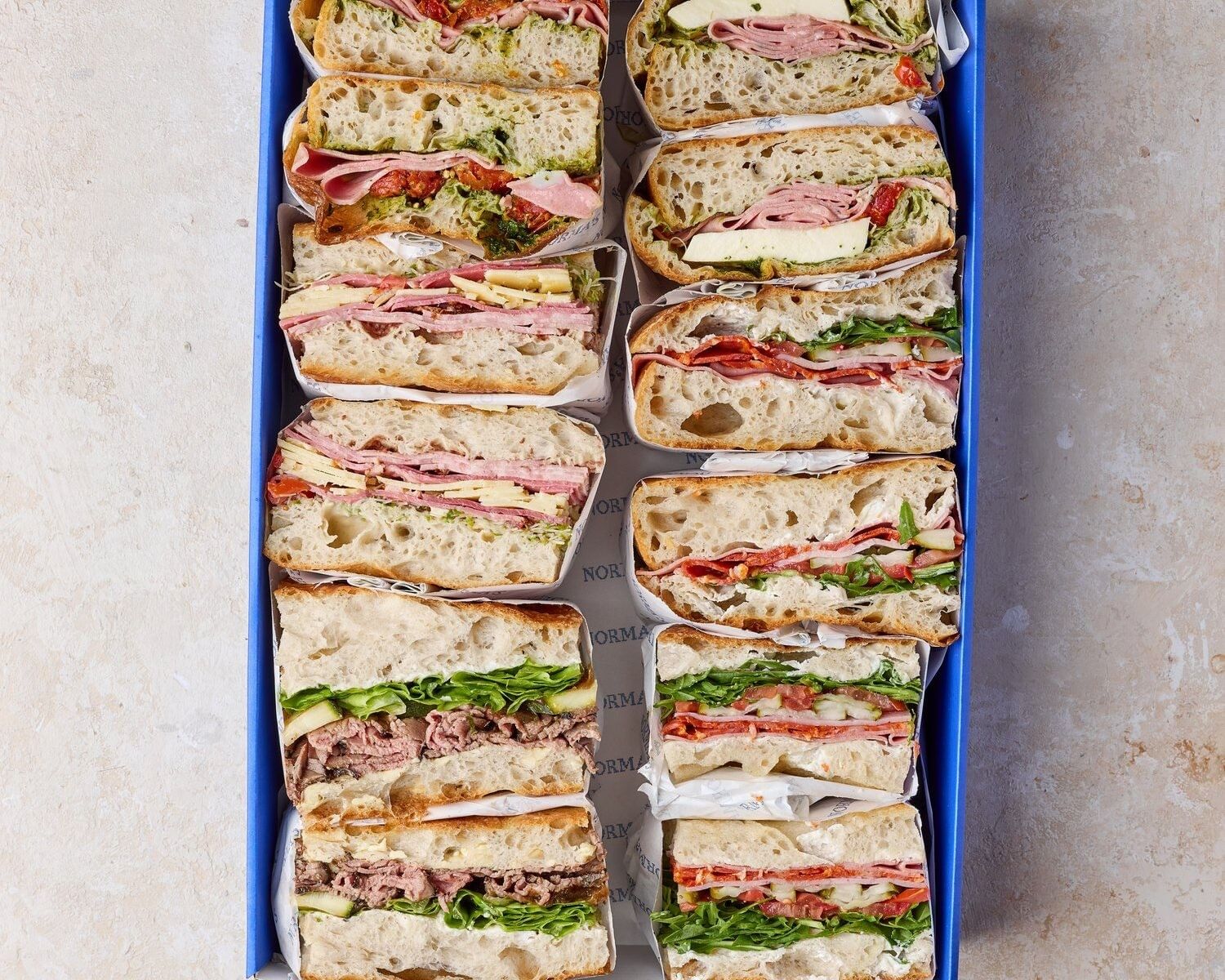 Norma's Deli sandwich box at Elysium Hotels contains various gourmet sandwiches with fresh meats and greens on sourdough bread