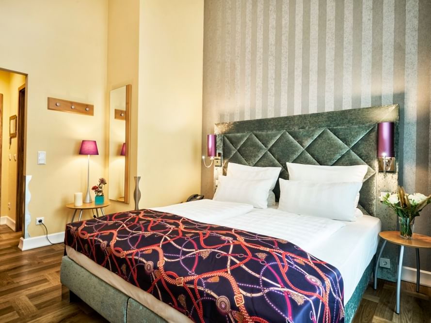 Tufted king bed in Triple Room at Classic Hotel Harmonie