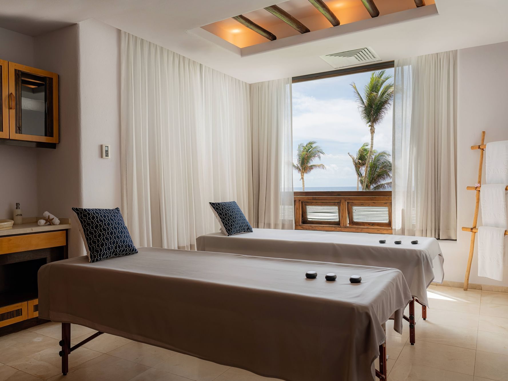 A relaxing massage cabin with two massage tables, overlooking the sea.