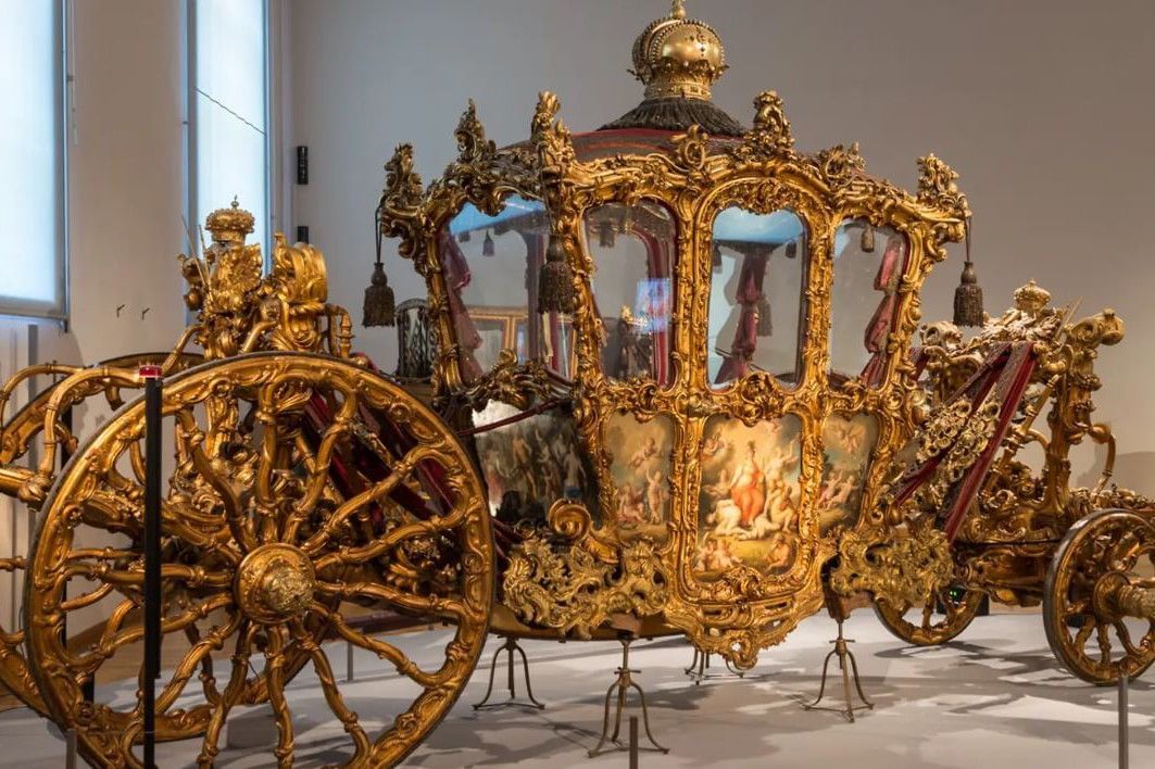 Ornate imperial golden carriage at the Imperial Carriage Museum Vienna featuring elaborate decorations and painted details