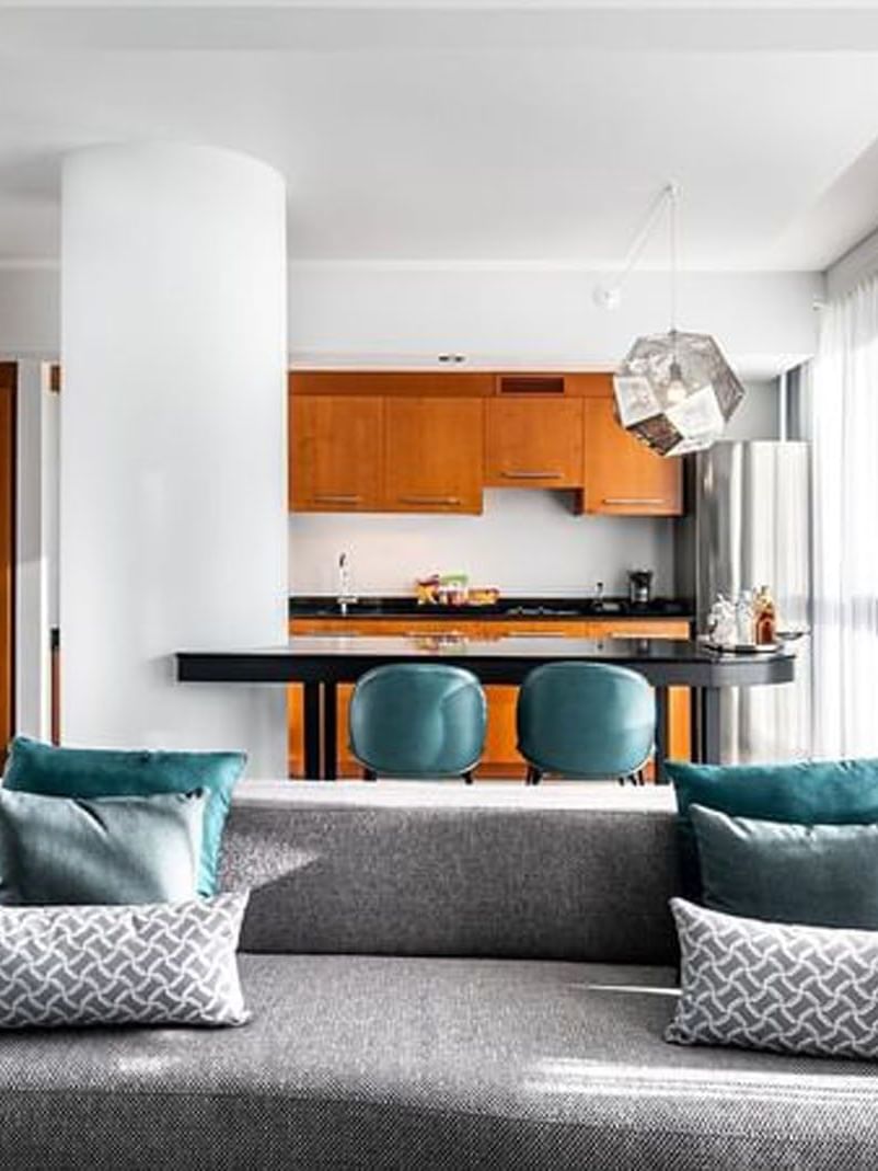 Penthouse Crescent living area with a sofa by a kitchen island with stools at Warwick Le Crystal Montreal
